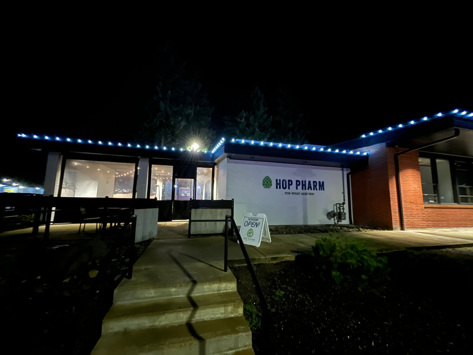 A brewery building lit with blue roofline lights at night