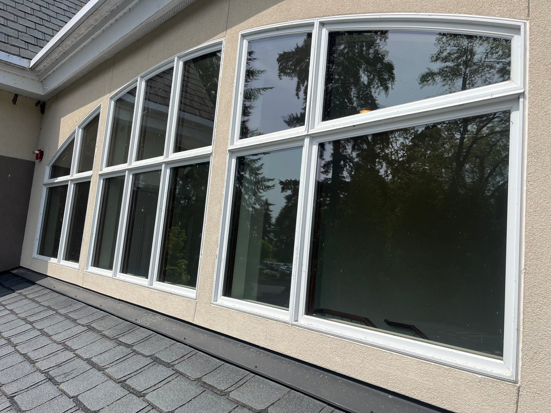 A window with visible streaks and cobwebs before cleaning