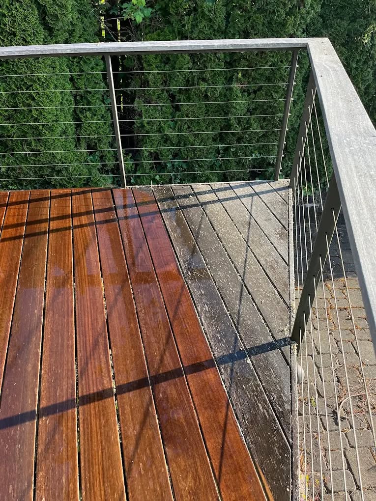A deck half restored, clean warm wood on one side and weathered grey on the other
