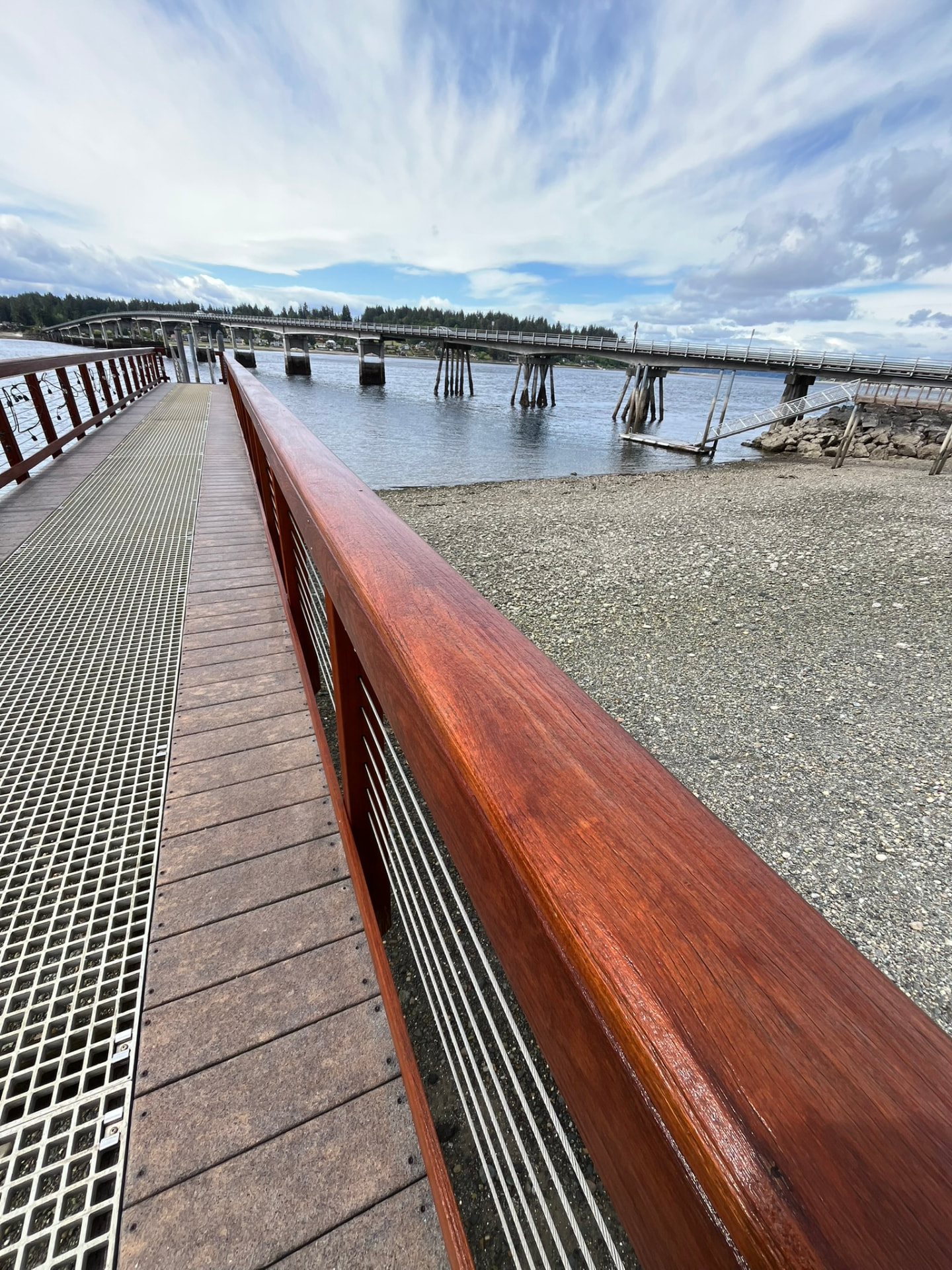 A freshly stained wooden deck railing with cable infill and a clean walkway behind