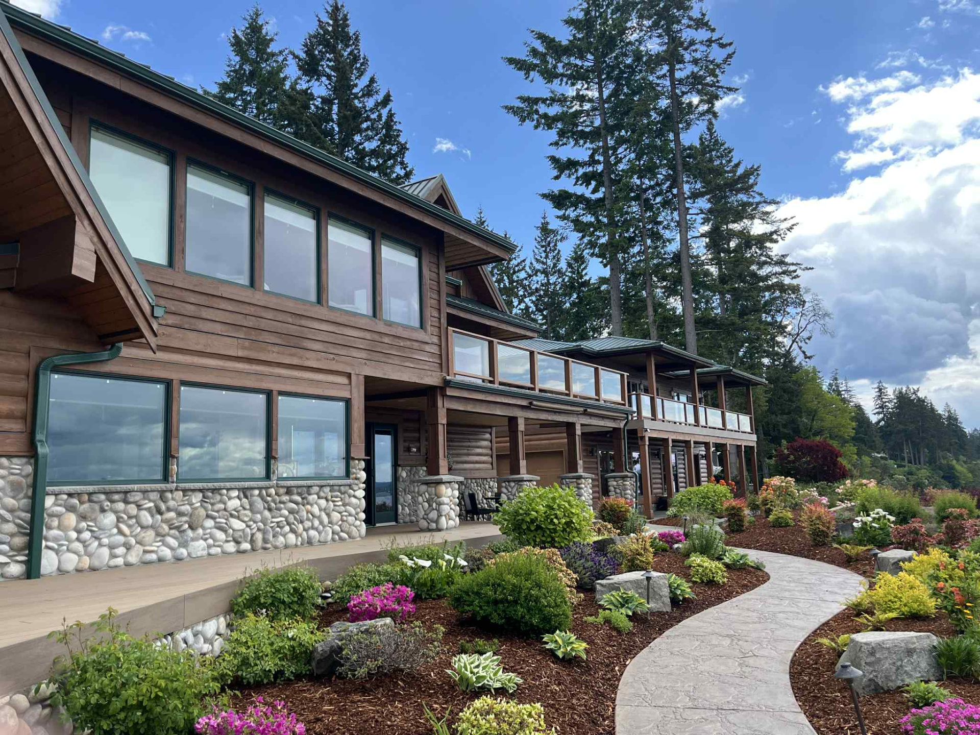 A large timber house with clean windows and a landscaped garden